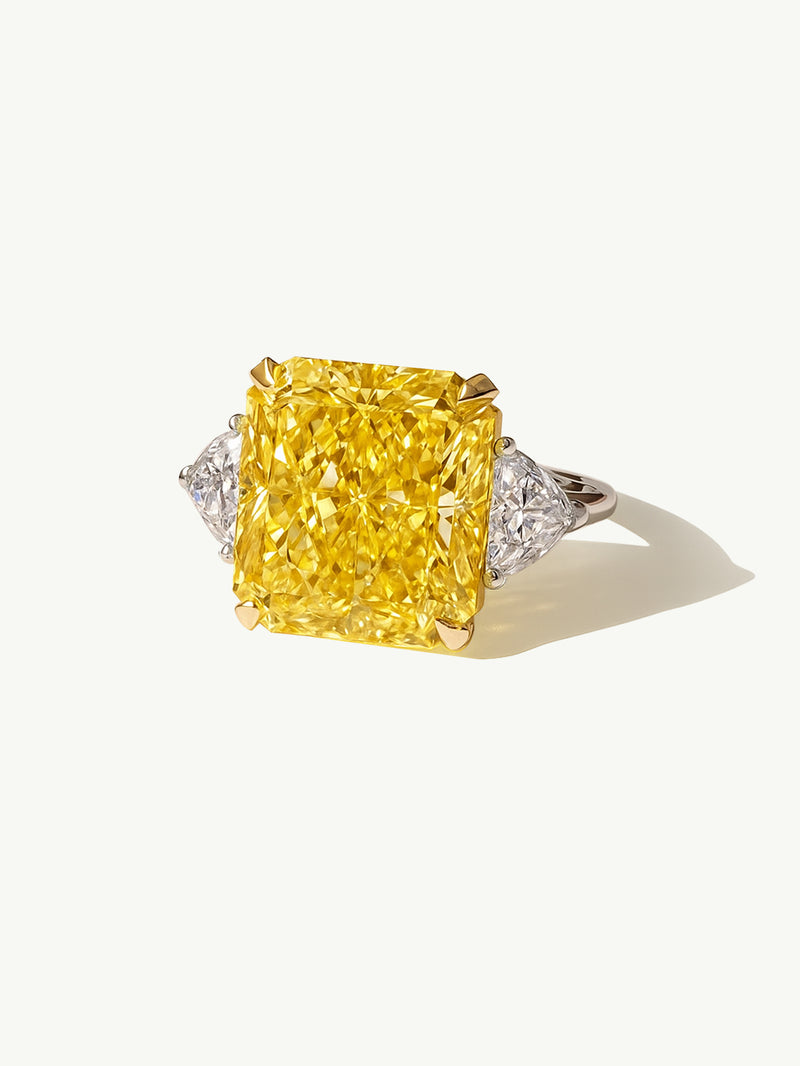 Ring with a large yellow diamond and smaller diamonds on a white background